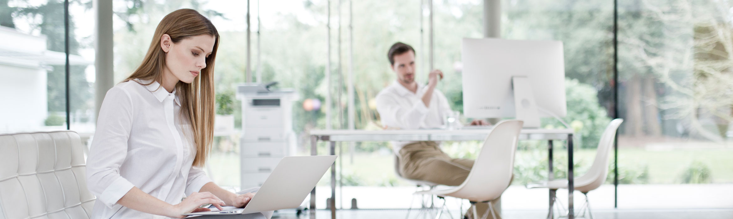 Man and woman working on their computers at home